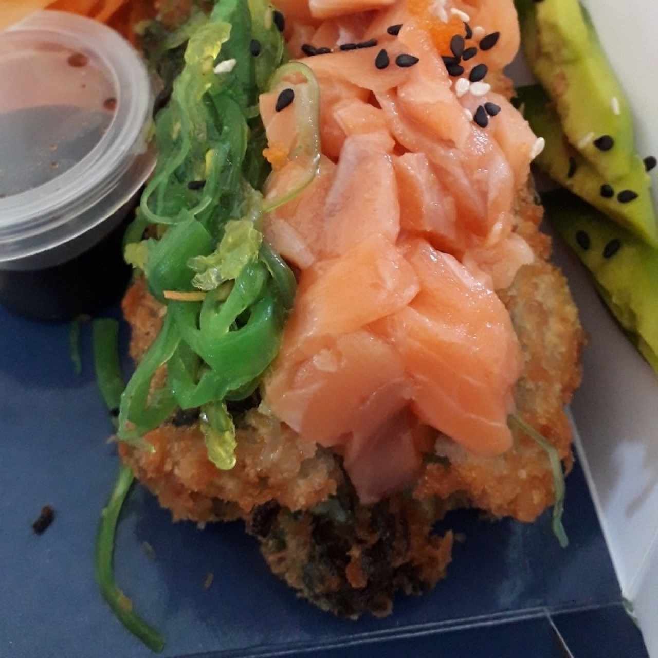 sushi hot dogma relleno de ensalada dinamita, auton o salmón, salame, aguacate y huevas de cangrejo, bañado en salsa anguila y dragon