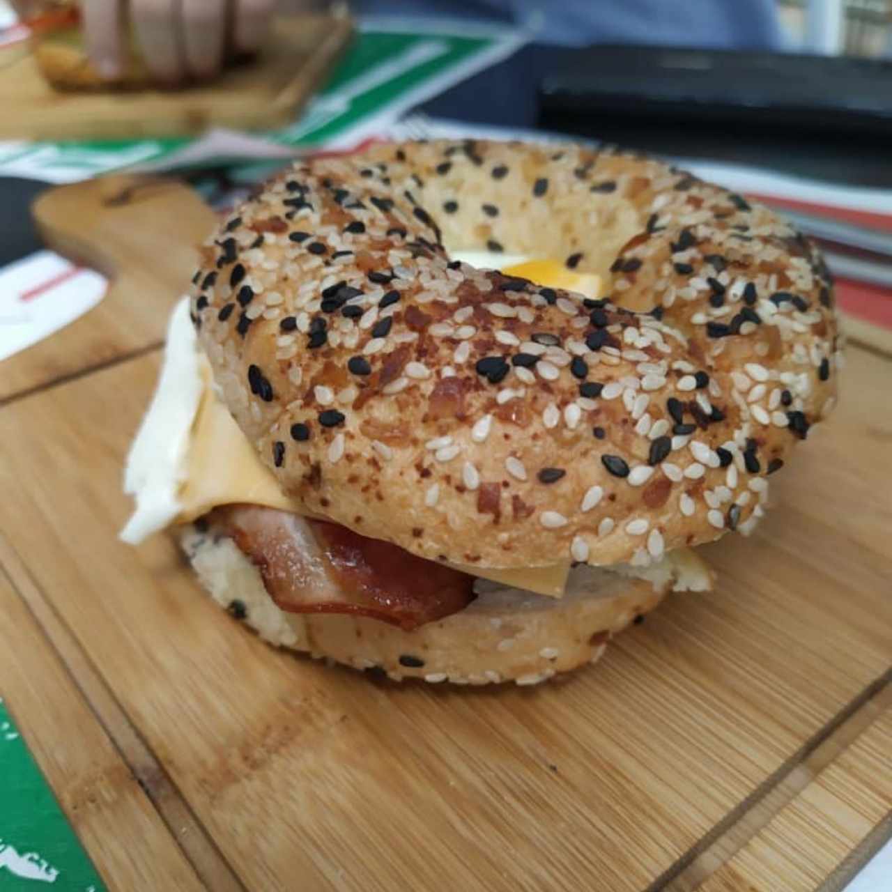 Bagel con tocineta, huevo, queso y aguacate
