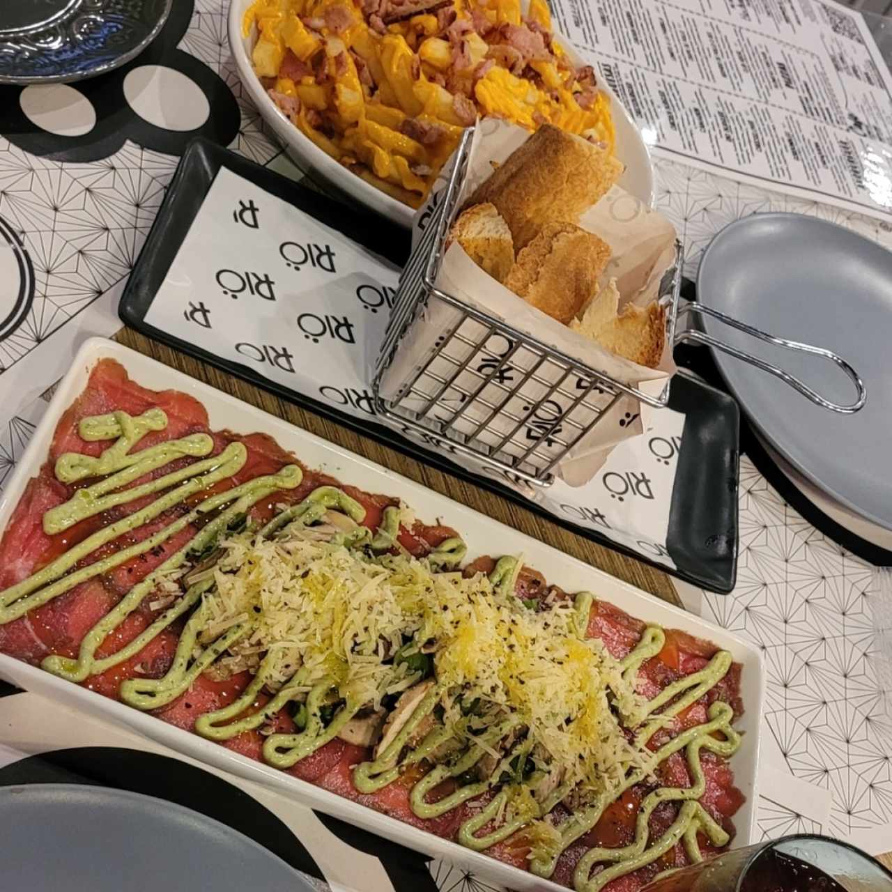 Carpaccio y papas con queso y tocineta