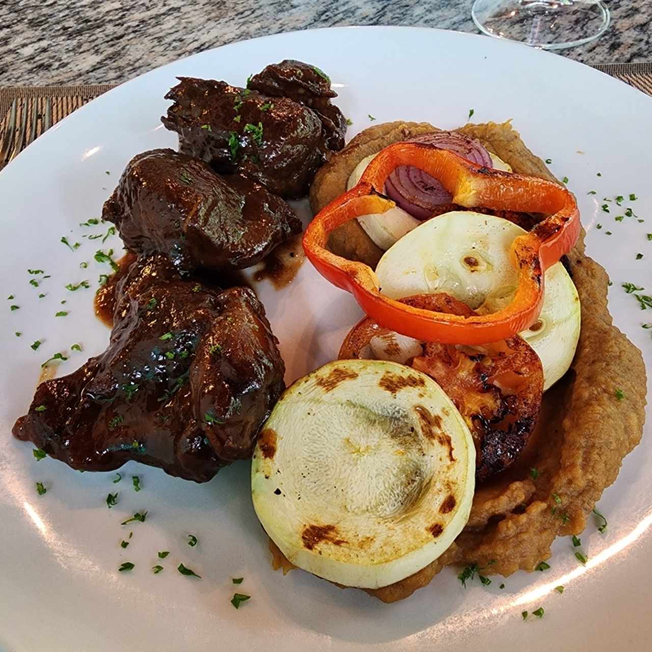 Asado negro de cordero, con vegetales al fierro, en cama de puré de plátano 