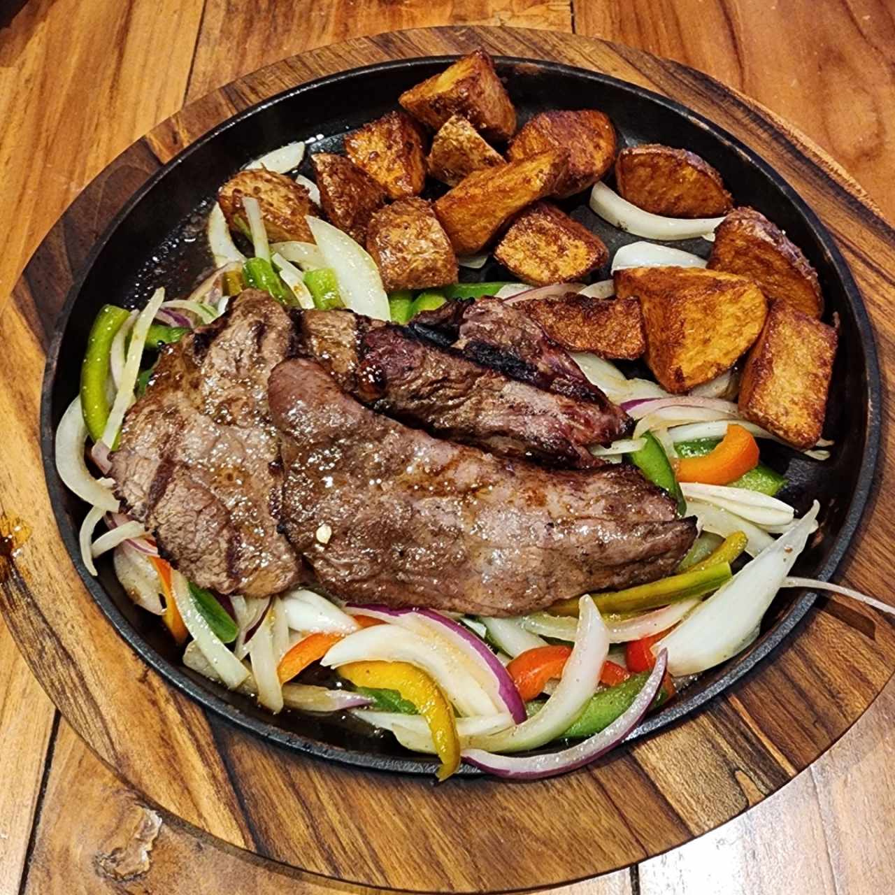 Lomito en cama de vegetales salteados con papas rústicas 