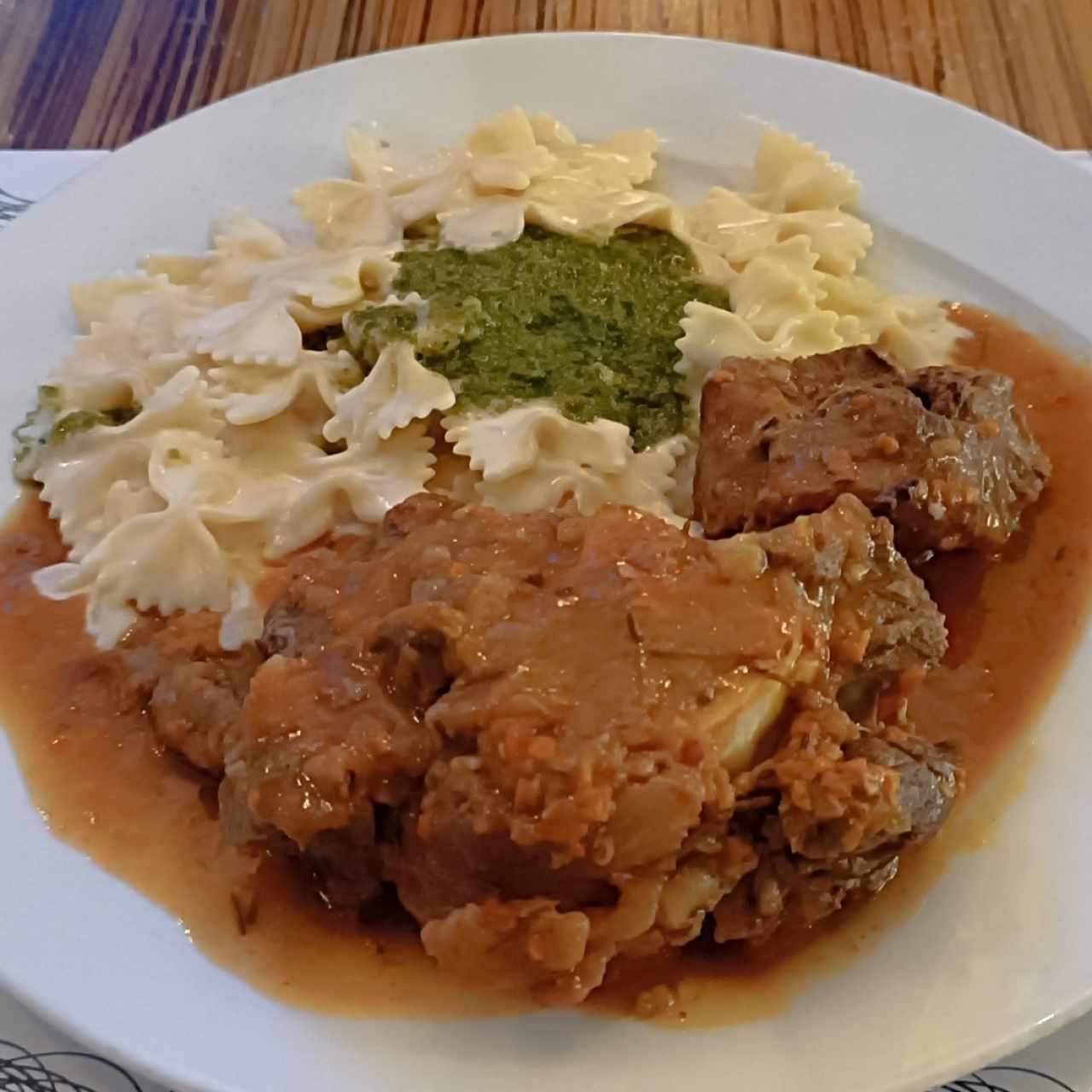 Ossobuco acompañado de farfalle en crema y con pesto
