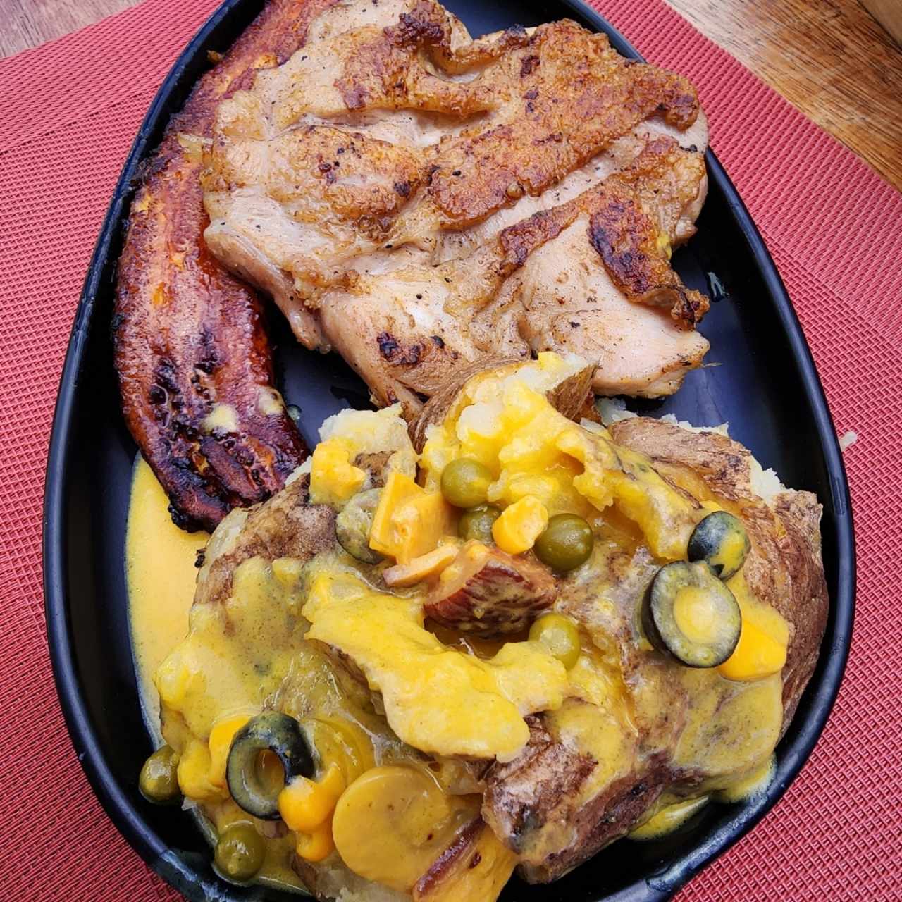 Churrasco de pollo + papa en salsa de queso + tajadas 