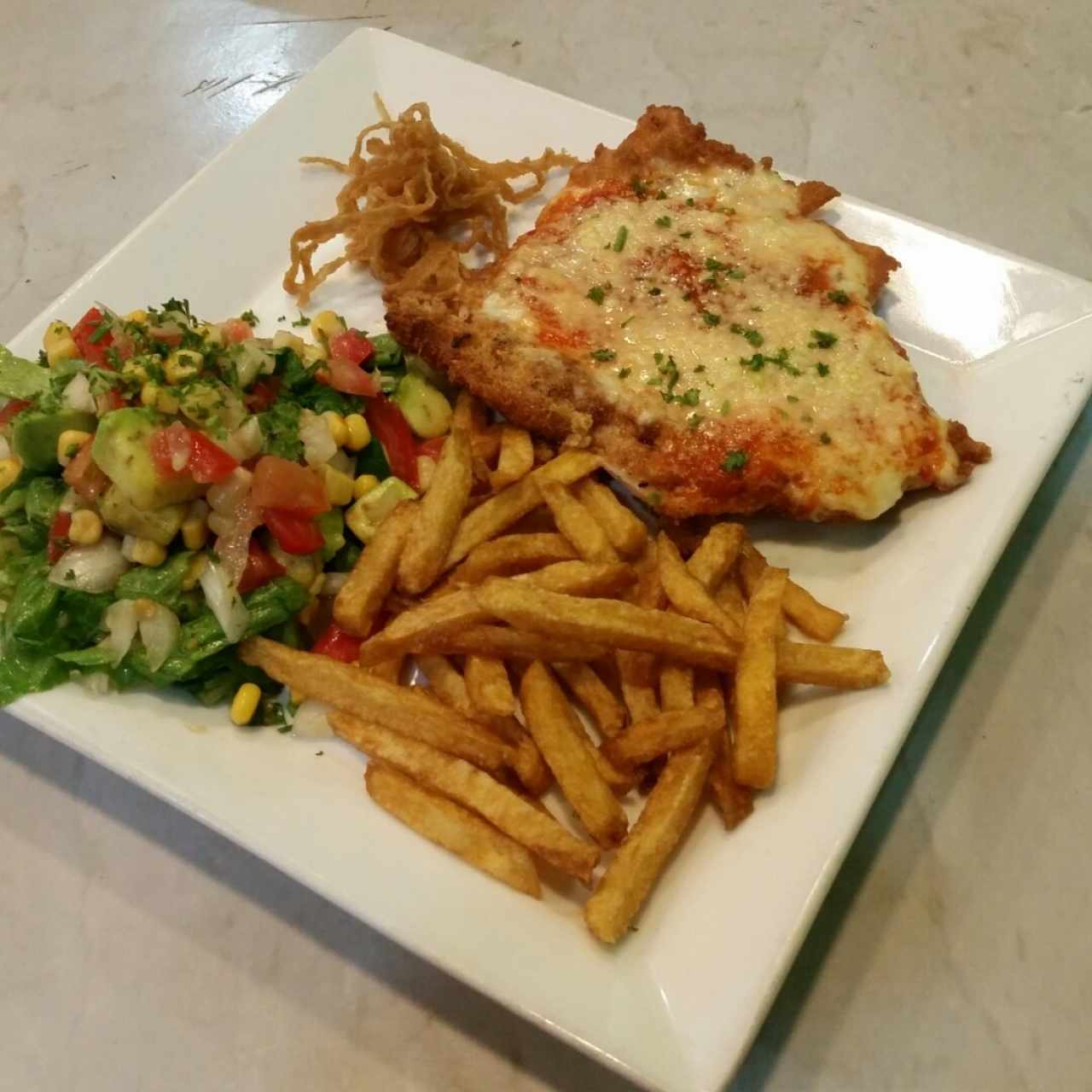 Pollo gratinado acompañado de papas fritas y ensalada además de unas ricas cebollas rebosadas 