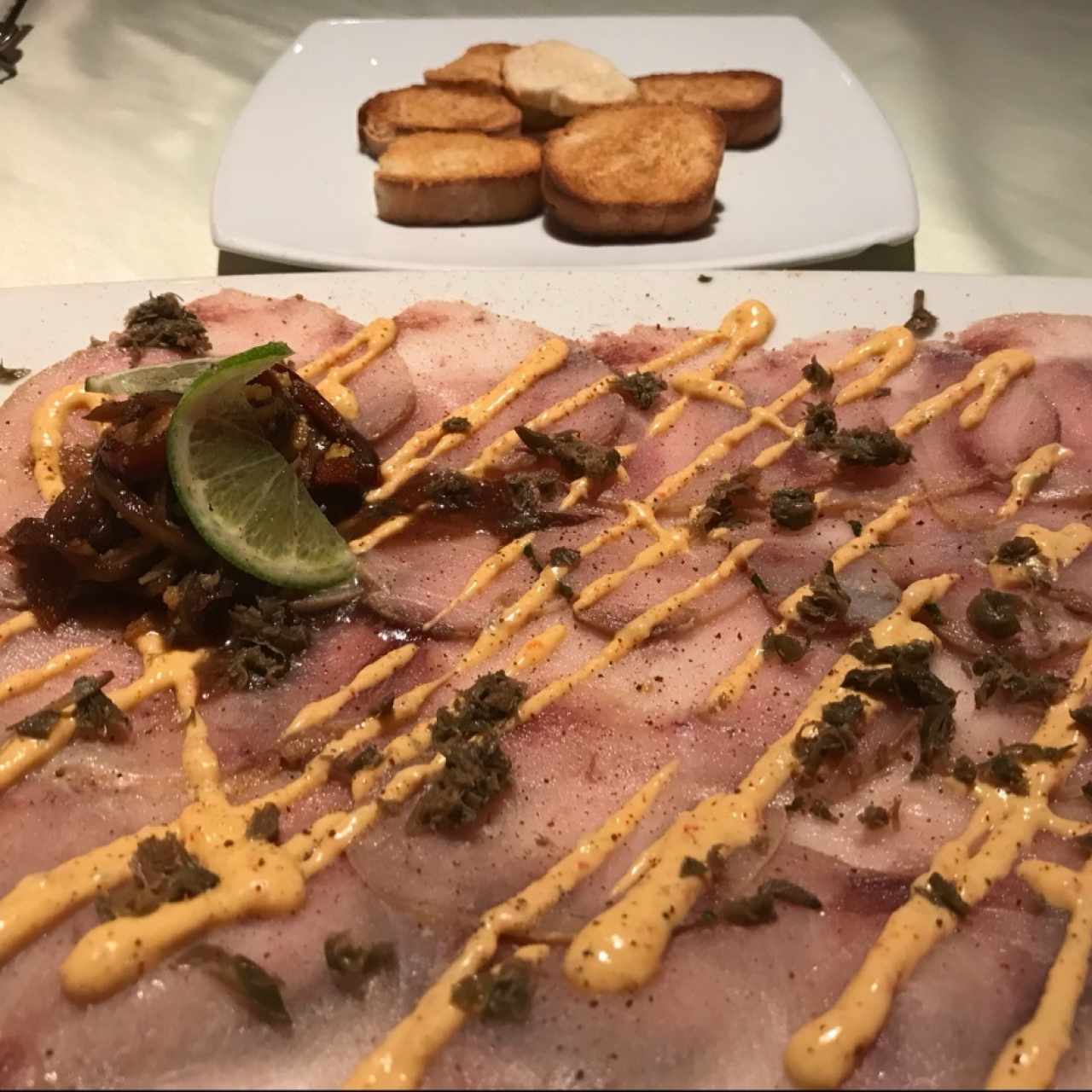 capaccio de pez espada con cebolla caramelizada y modtaza miel. unico