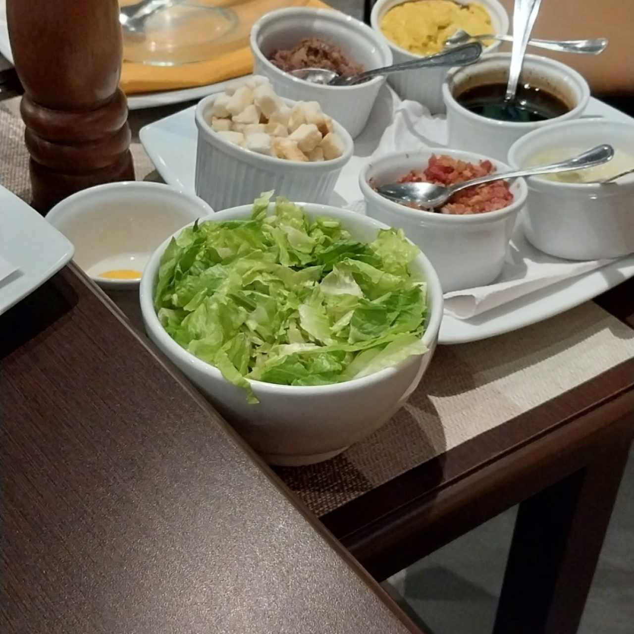 Preparación en mesa de ensalada César 