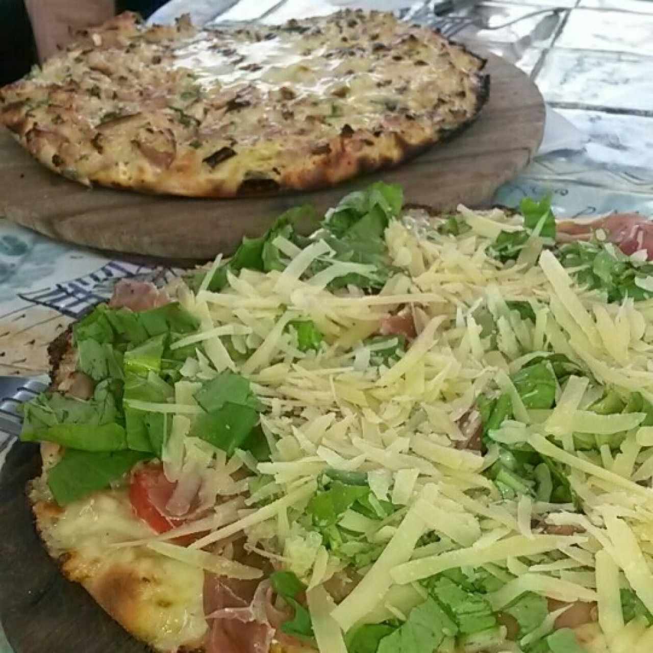 Crema tocineta y ajo porro al fondo,  y rucula y serrano al frente