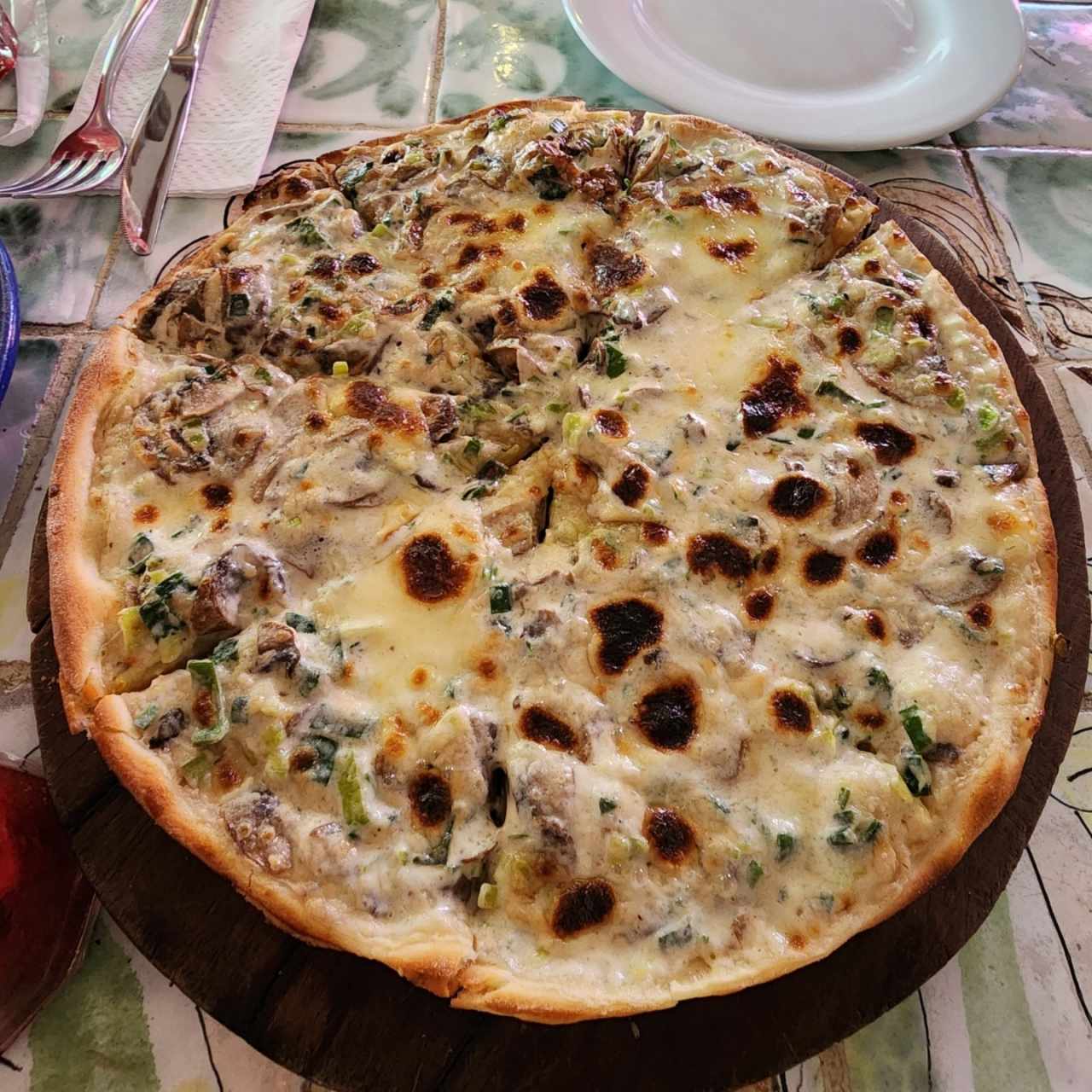 Pizza a la crema con ajoporro y champiñones