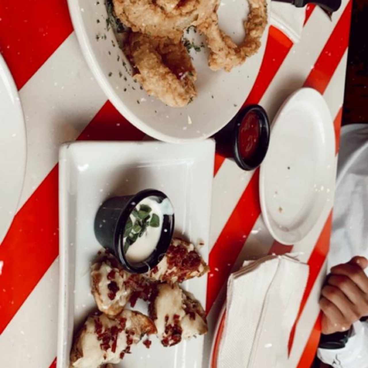 aros de cebolla y conchas de papas con queso fundido y tocineta.
