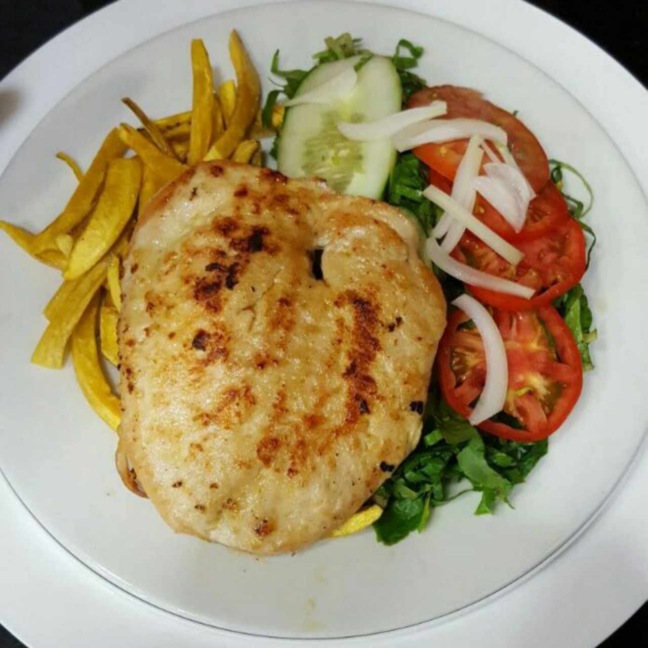 milanesa de pollo a la plancha con tostones y ensalada mixta