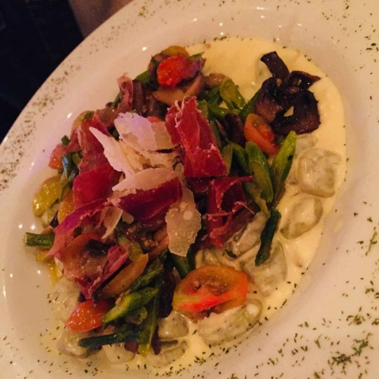 Ñoquis de espinaca en crema blanca con teopezones de tomate cherry, espárrago, jamón serrano y champiñones.  
