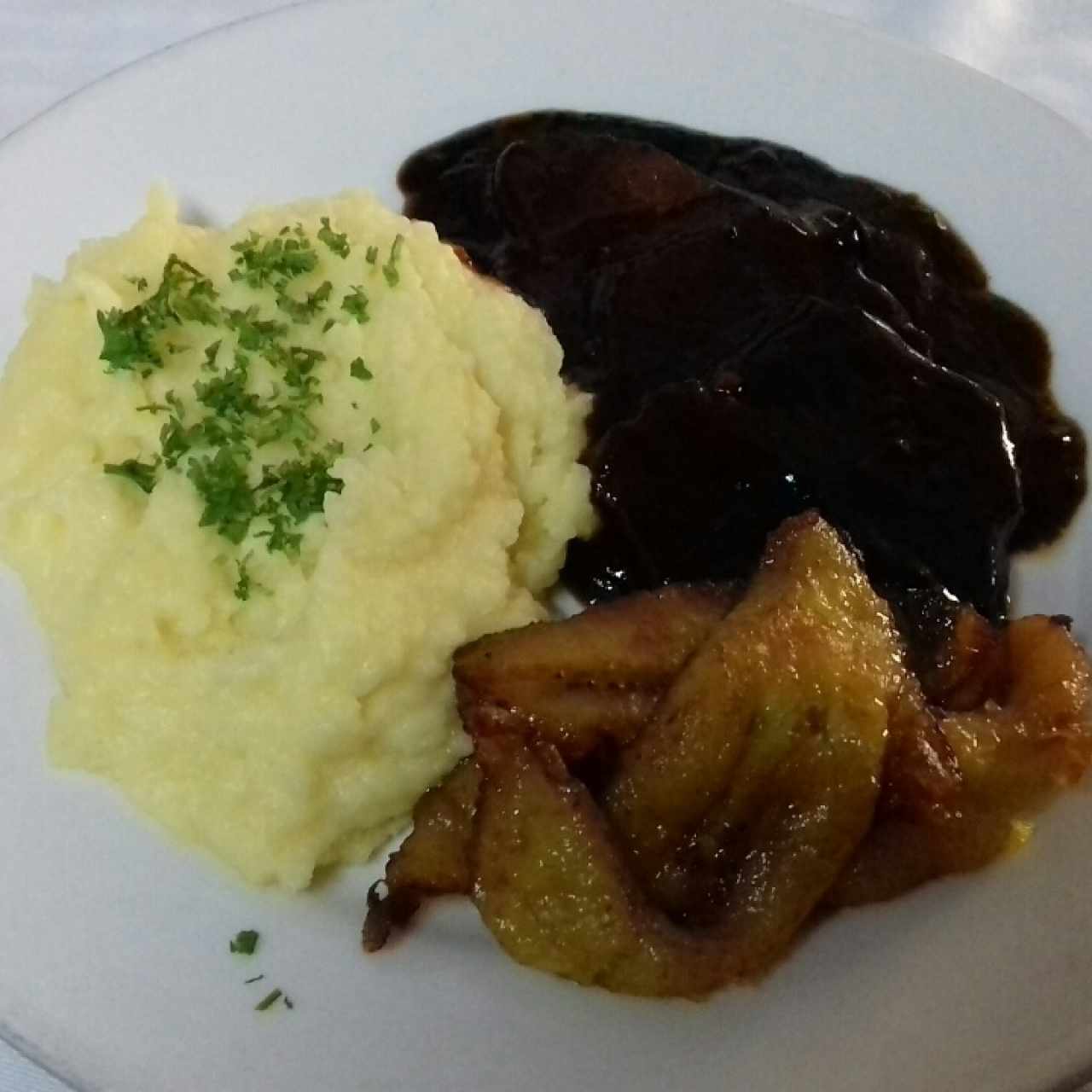 Asado negro, con puré de papas y tajadas 