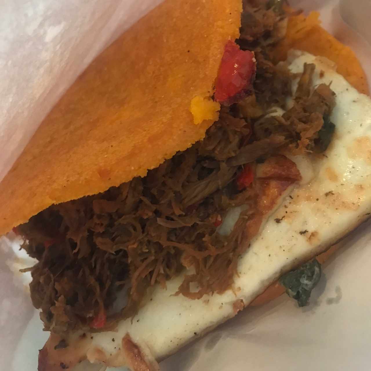 Arepa con masa de ají; mechada con queso a la plancha