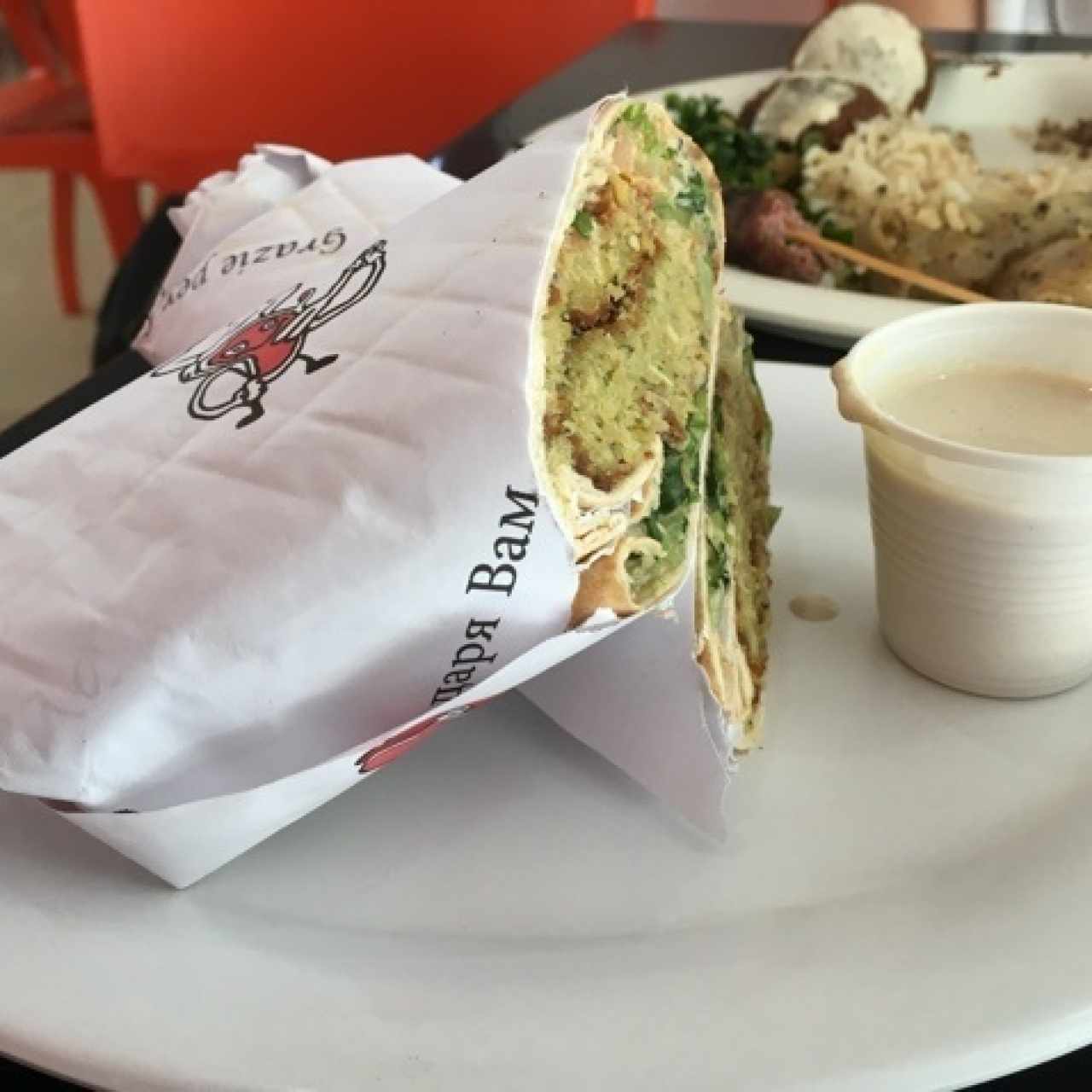 sandwich de falafel y al fondo plato mixto 