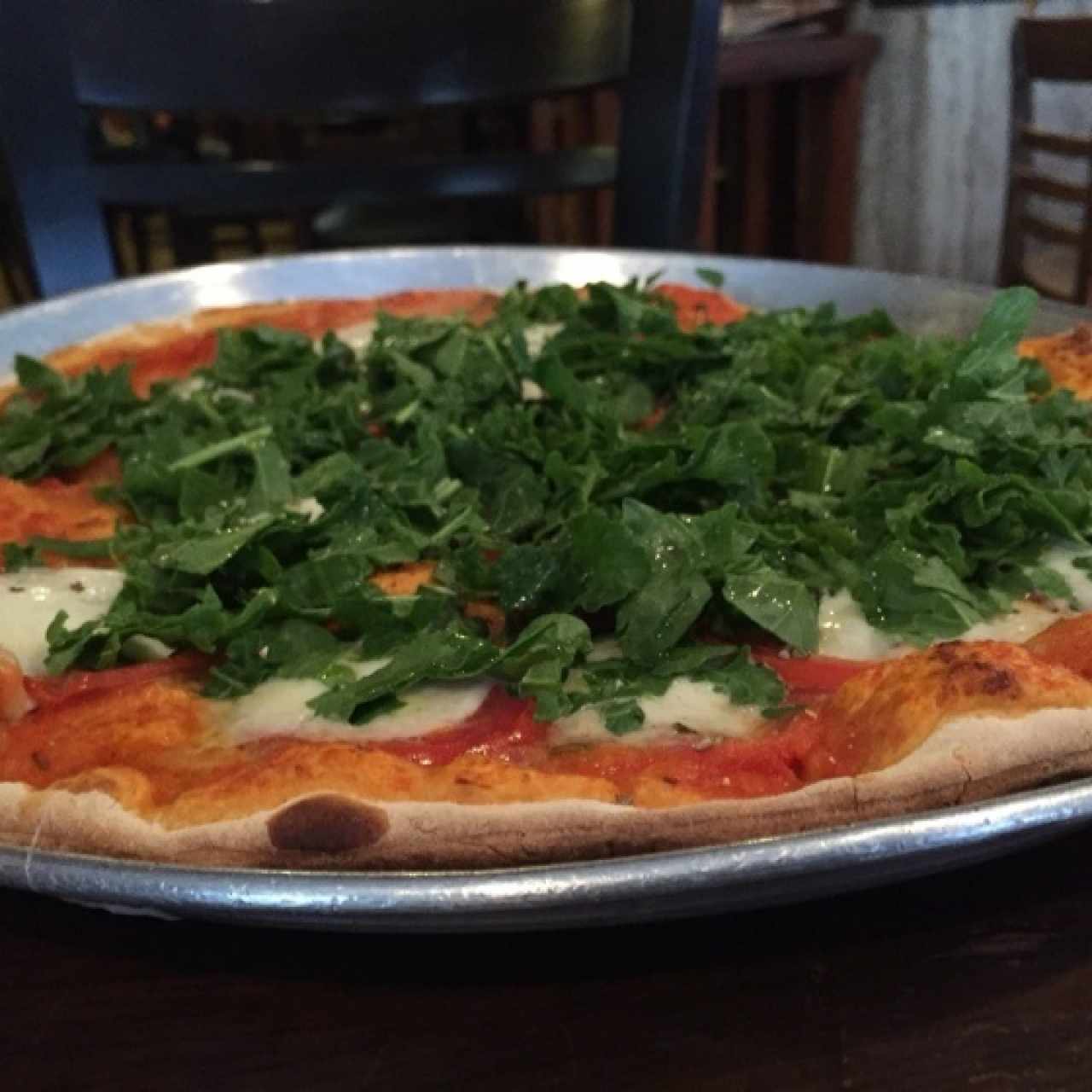 pizza con boconccini, tomate y rúgula.