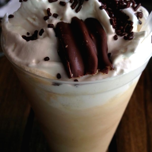 Café con chocolate blanco, crema, sirope de caramelo y pedacitos de alfajor 
