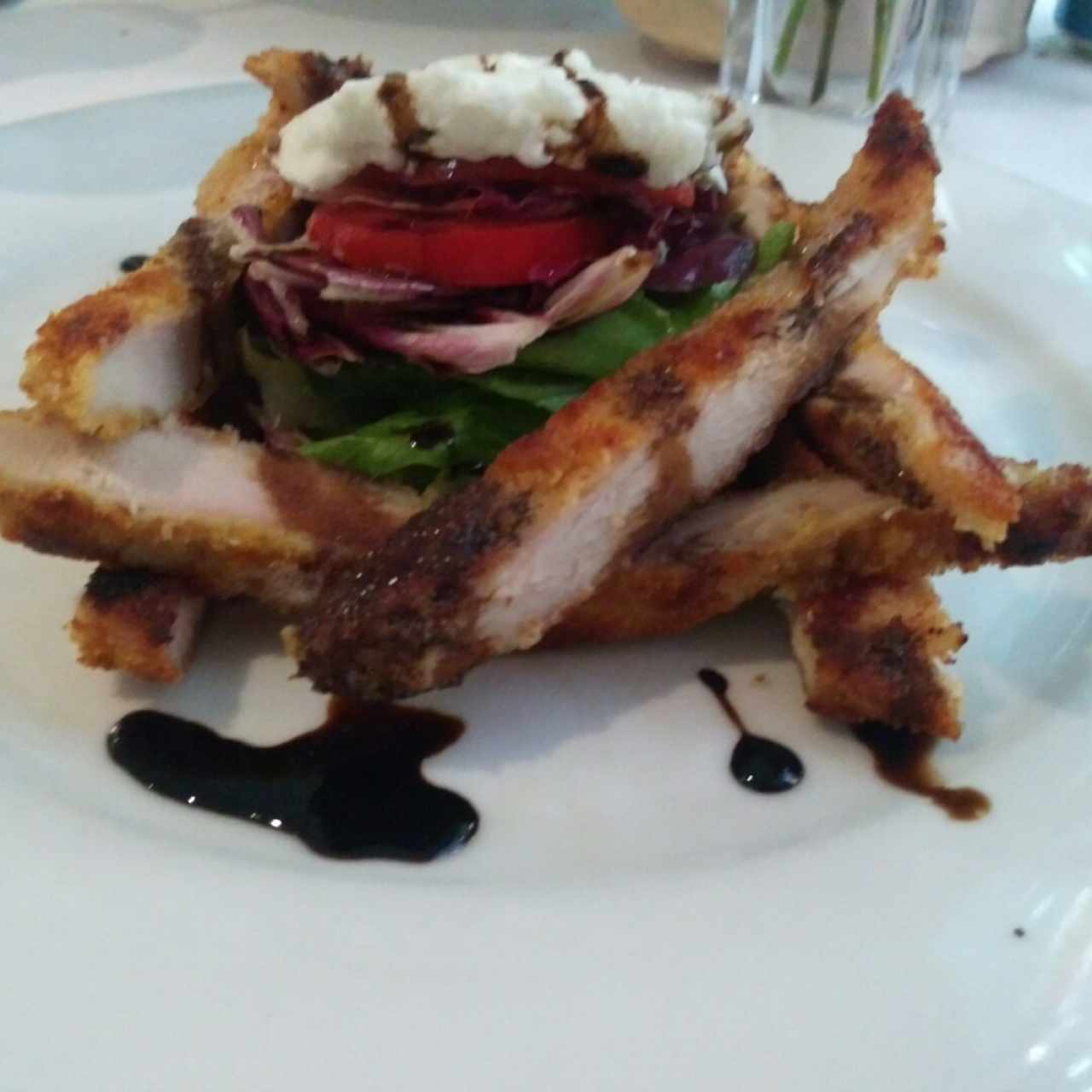 Cotoletta crocante de pollo en cama de lechuga, mozzarella y tomate con balsámico