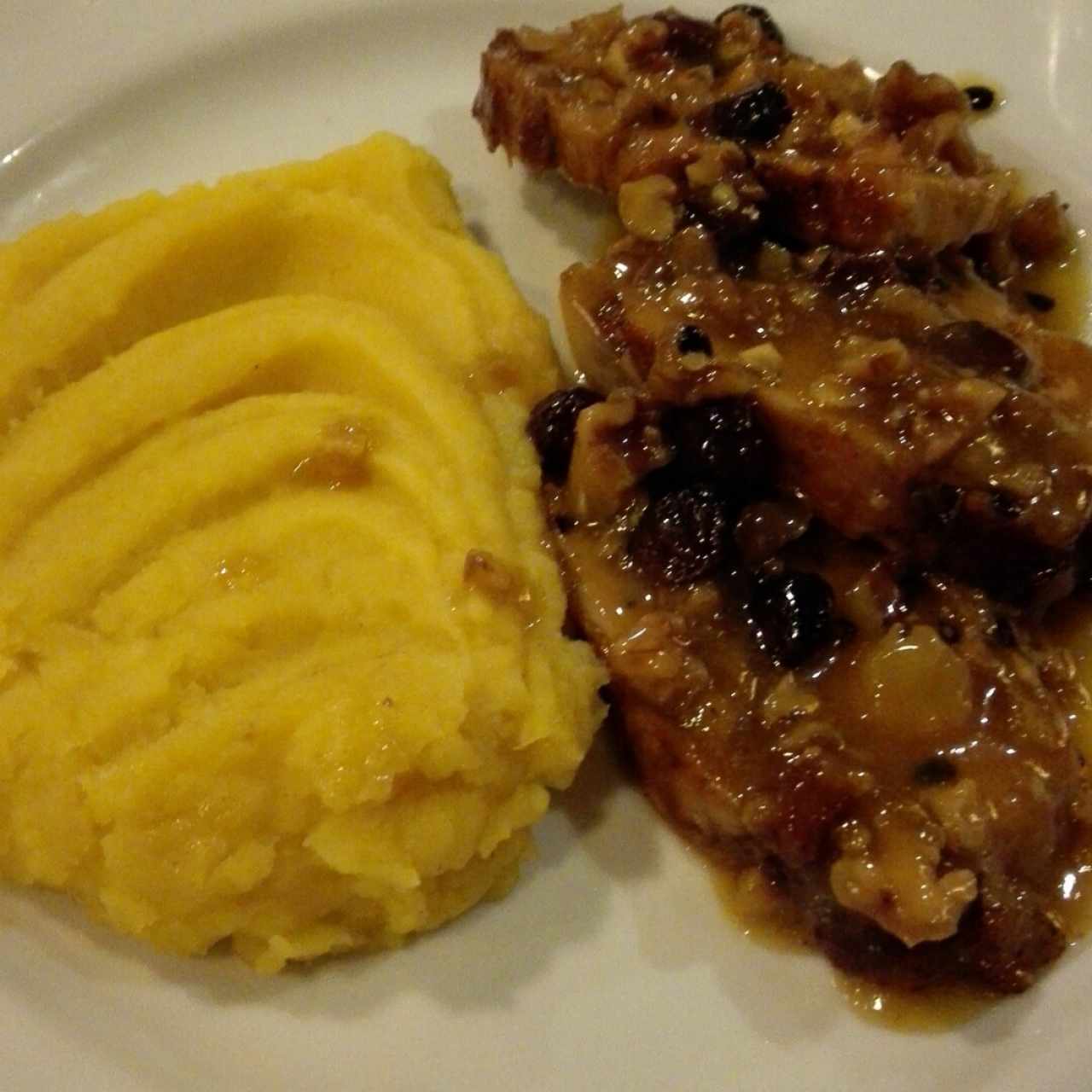 lomo de cerdo en salsa de fruta de la pasión con uvas pasas y nueces acompañante pure de batata