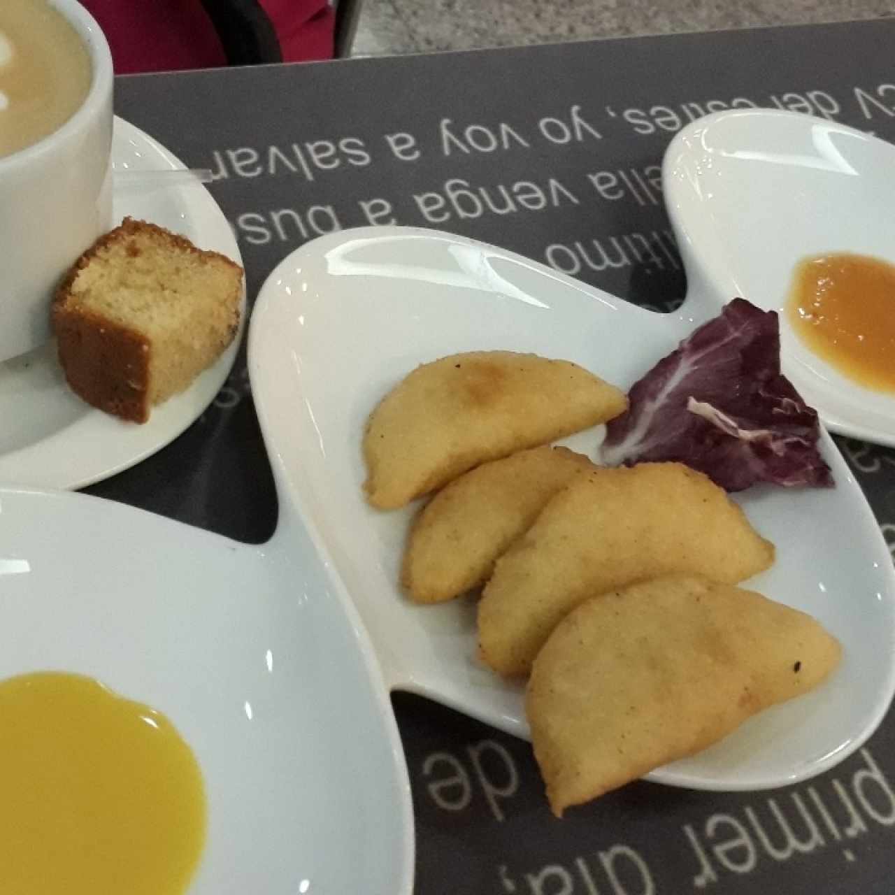 Entrada de empanaditas de cazón y café con leche grande.