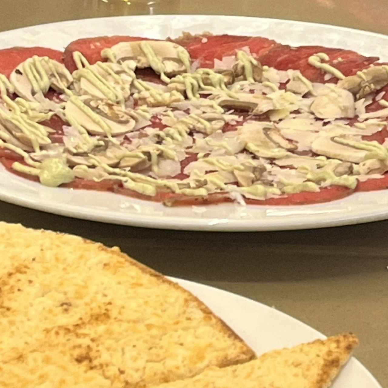 Carpaccio de carne y casabe gratinado 