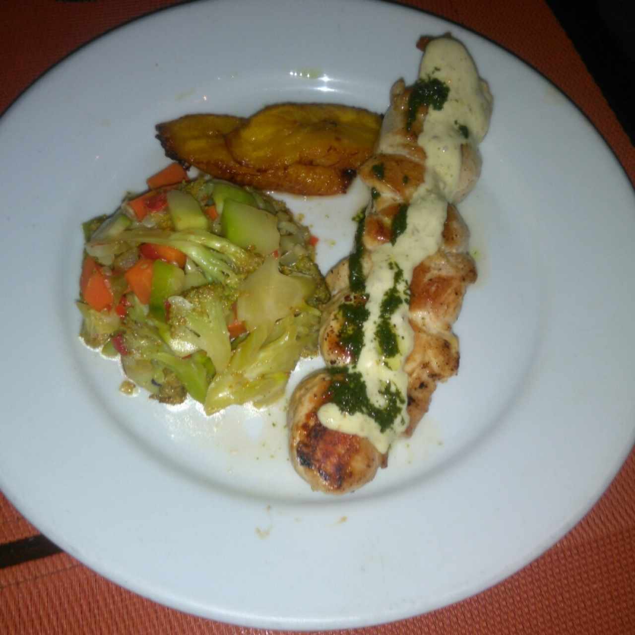 Pincho de pollo acompañado con vegetales y tajadas 