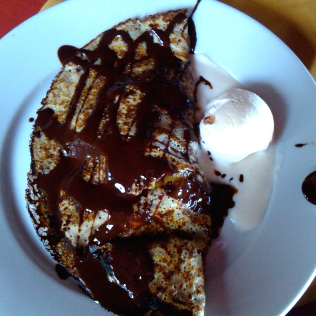 Crepe rellena con cambur y cubierta con chocolate.