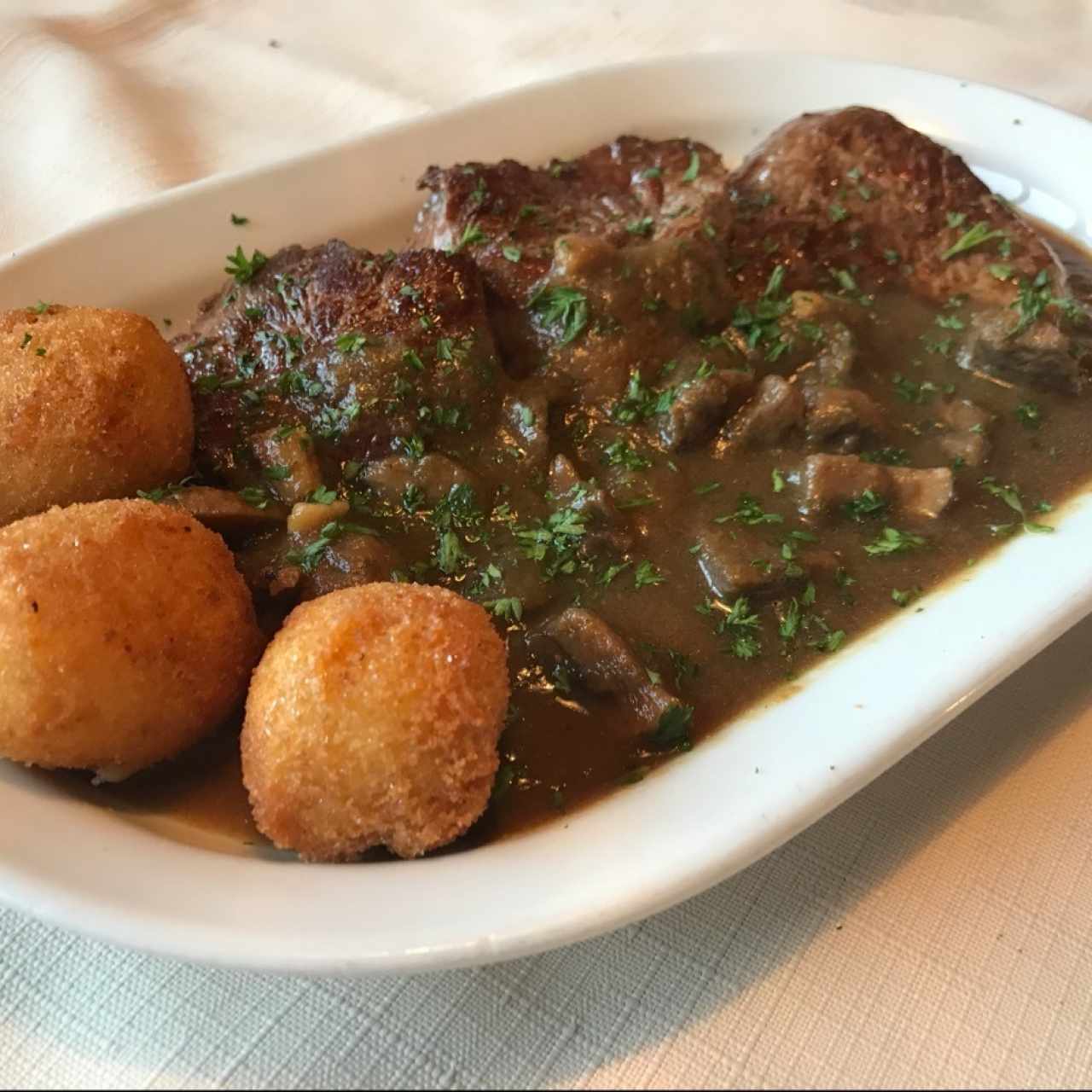 Lomito con champiñones y croquetas de papa