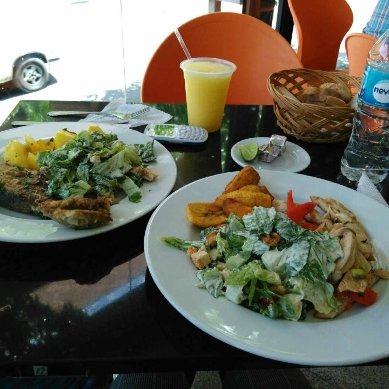 Plato izq: Dorado frito, ensalada césar y papas salteadas. Plato der: pollo salteado con vegetales, tajadas y ensalada césar.