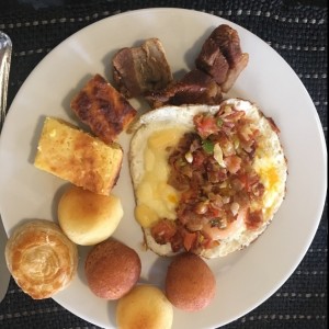 Huevos fritos al gusto (tomate, cebolla, tocineta y queso), buñuelos, pandebonos, torta de maiz, chicharrón
