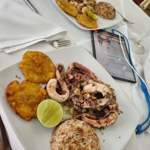pulpo al ajillo acompañado de arroz con coco y patacones.