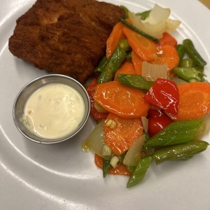 Filete de corvina apanado con vegetales salteados