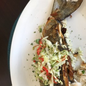 trucha al horno sobre una cama de arroz con almendra.