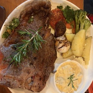T Bone steak con papas salteadas, mac & cheese, ajo y vegetales