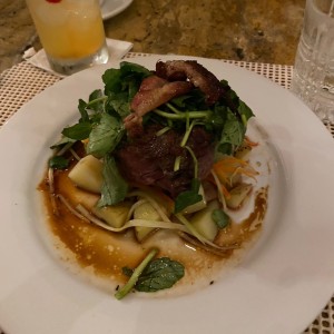 Tournedo con tocino, berro tibio, vegetales al hilo y papitas