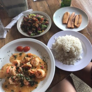 Camarones al ajillo con arroz, ensalada y tajadas.