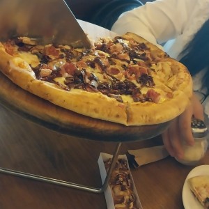 Pizza tocino, cebolla caramelizada, salchicha y claro queso