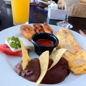 Omellete champiñones, tocino, queso acompañado de frijoles, plátanos y salsa