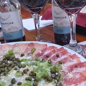 carpacho de salmón acompañado de vino tinto