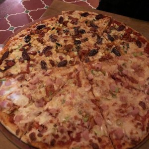 pizza con jamon de lomo y cebollin, zuchini con pimientos rojos y alcaparra