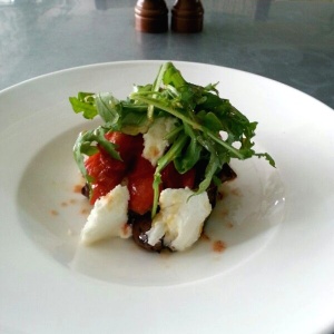 Mozzarella salad with arugula, peppers and eggplant.