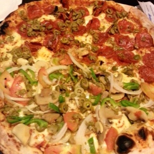 Pizza mitad vegetariana y mitad peperoni con aceitunas