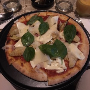 pizza con: mozarella, lajas de parmesano, albahaca, tomate seco y extra de alcachofa