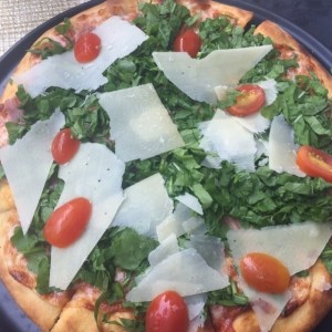 pizza de rugula parmesano y tomates cherry