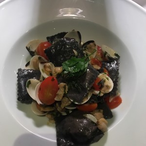 Raviolea relleno de salmon con tinta de pulpo y almeja