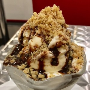 Copa de helado de vainilla con sipore de chocolate, malva y nueces