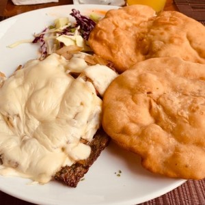 Bistec de Res Encebollado con Queso Gratinado y con Hojaldres