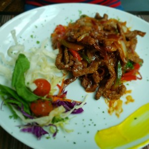 Bistec sobre papas bravas