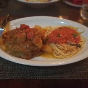 Cordero al horno con pasta en salsa roja.