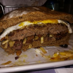 Huevo, aceitunas, tocino, papas crack, pan integral y carne vacuna