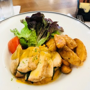pollo relleno de espinaca en una cama de pure de camote.